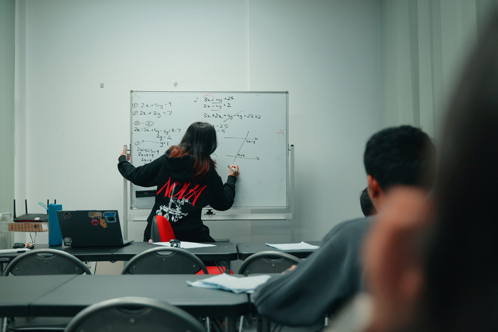 A Spartan Tuition tutor solving simultaneous equations on the whiteboard