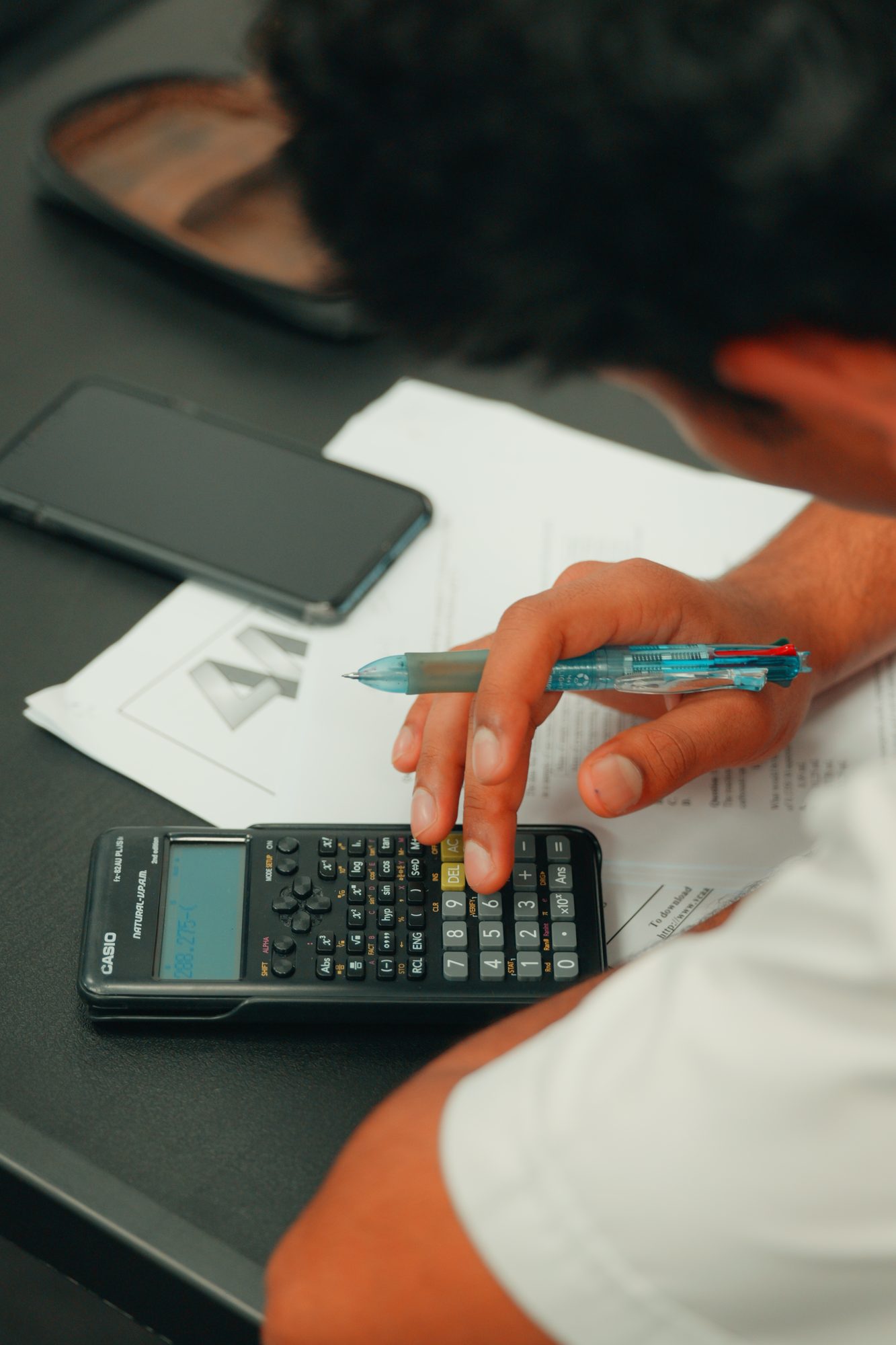 A student working through a problem with a calculator