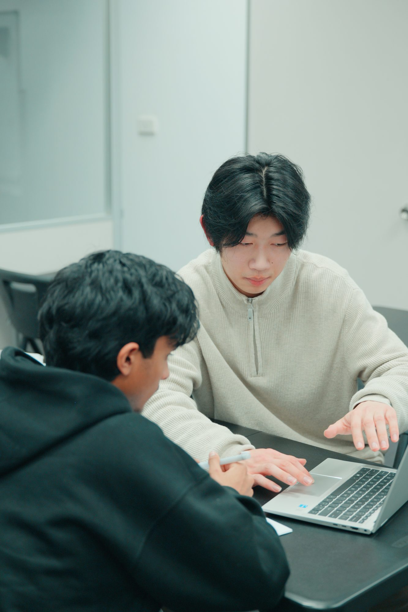 A Spartan Tuition tutor helping a student at a laptop during a private lesson